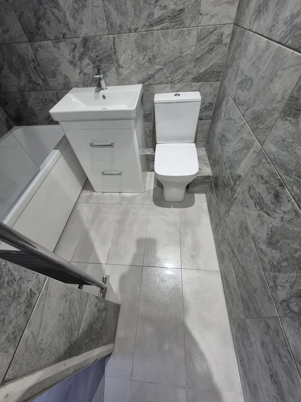 White basin unit and toilet with light grey flooring — Queenborough bathroom renovation
